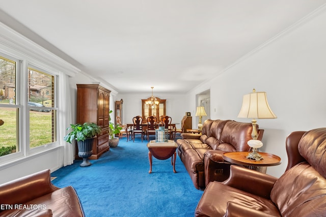 living room featuring ornamental molding, carpet, and an inviting chandelier