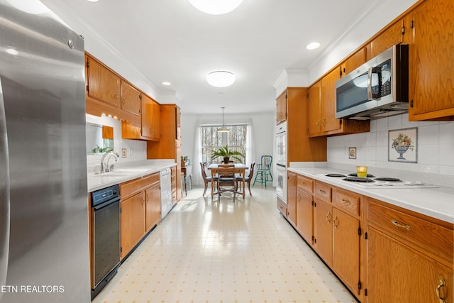 kitchen with ornamental molding, hanging light fixtures, stainless steel appliances, and decorative backsplash