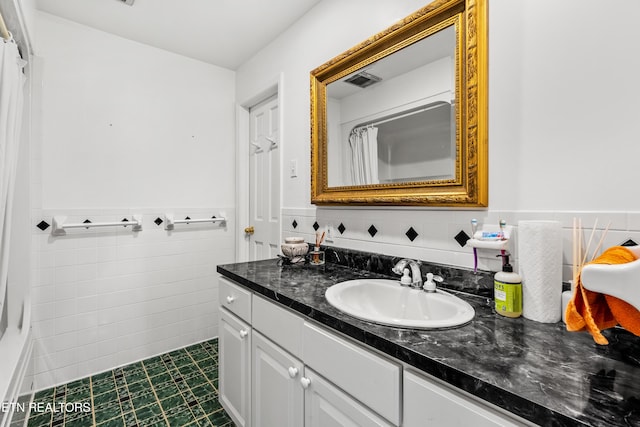 bathroom featuring tile walls and vanity