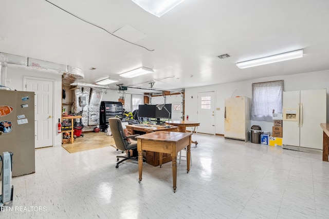 interior space featuring white fridge, stainless steel fridge, a garage door opener, and white fridge with ice dispenser