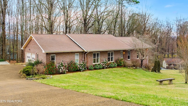 ranch-style home with a front yard and a garage