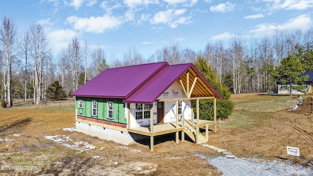 unfinished property featuring an outbuilding, metal roof, and crawl space