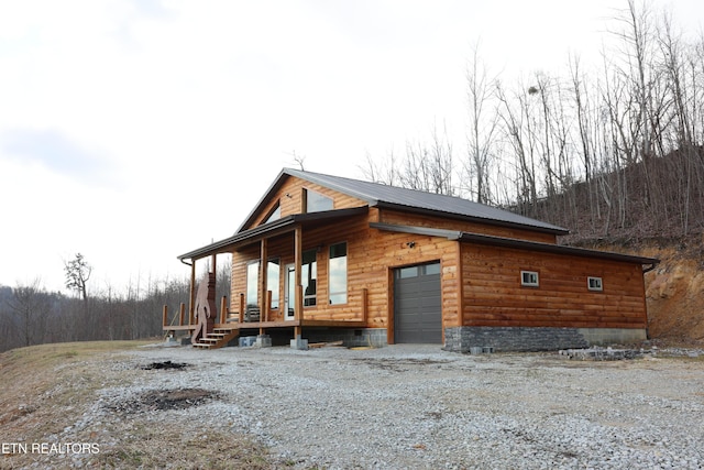 view of property exterior featuring a garage and covered porch