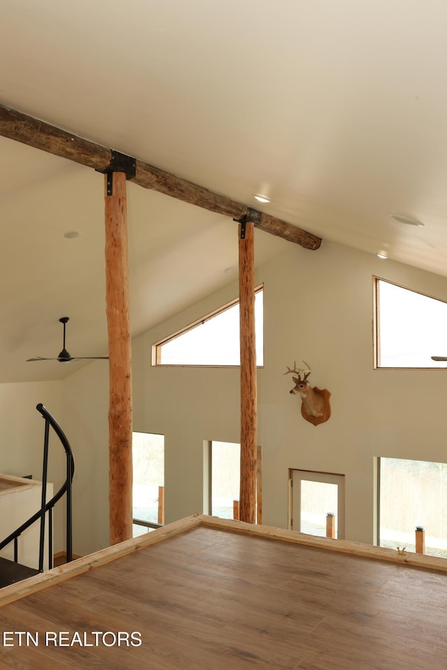 spare room with wood-type flooring, beam ceiling, and high vaulted ceiling