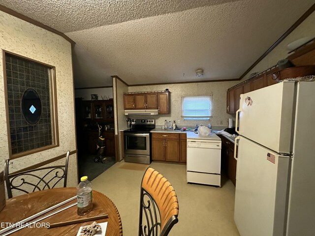 kitchen featuring lofted ceiling, a textured ceiling, white appliances, light countertops, and ornamental molding