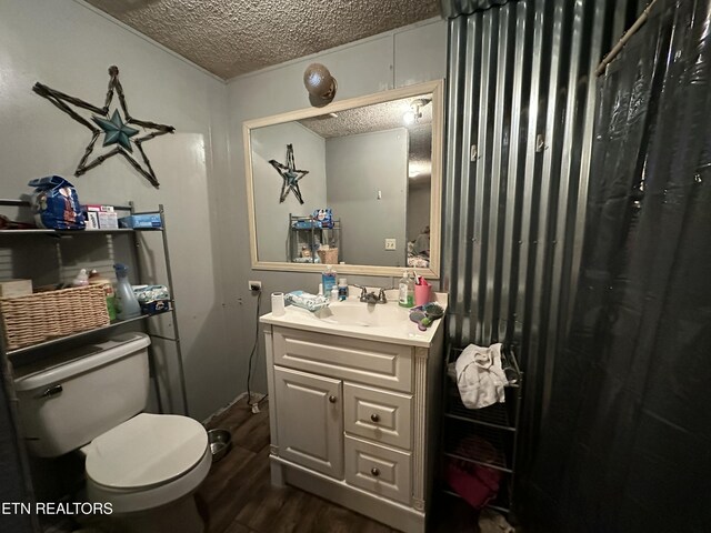 bathroom featuring a textured ceiling, vanity, wood finished floors, and toilet