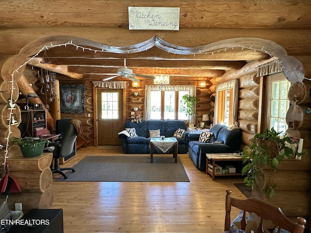 living area featuring beam ceiling and wood finished floors