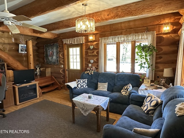 living room with light wood-type flooring, rustic walls, beamed ceiling, and ceiling fan with notable chandelier