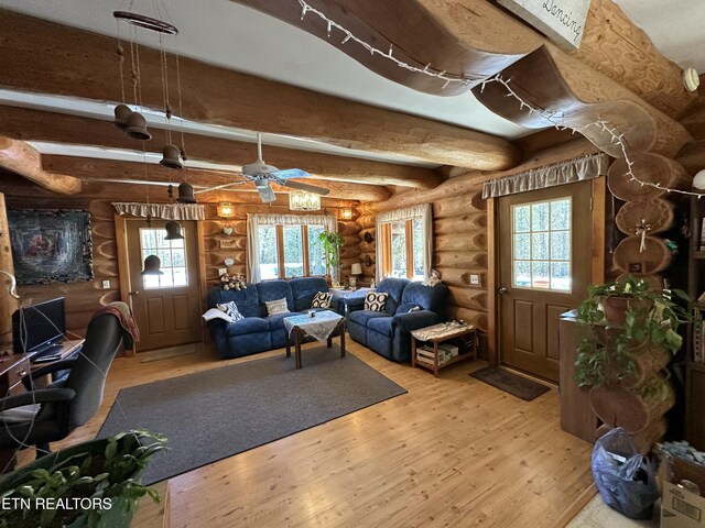 living room featuring rustic walls, beamed ceiling, and light wood finished floors