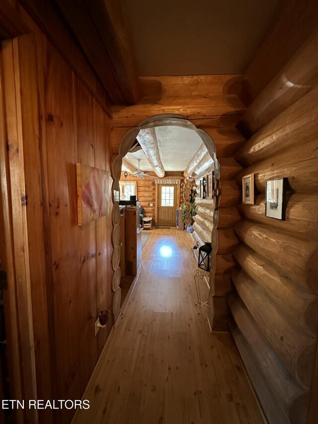 hall featuring arched walkways and light wood-type flooring