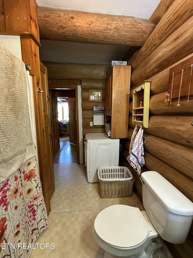 bathroom featuring toilet and washer / clothes dryer