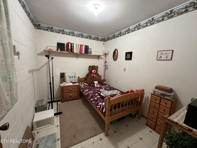 bedroom with concrete block wall