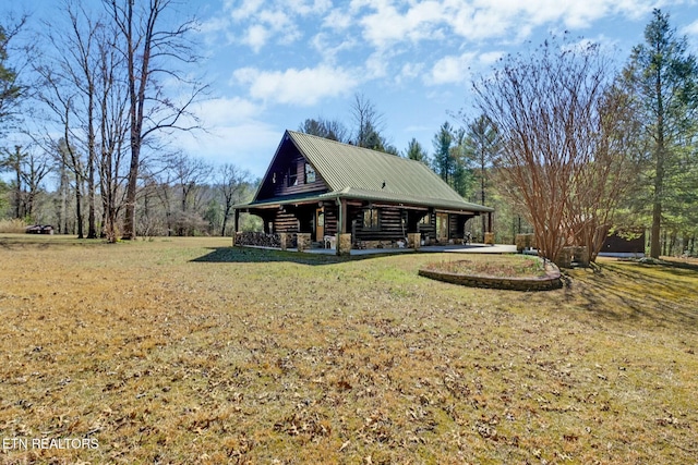 rear view of property featuring covered porch, metal roof, and a lawn