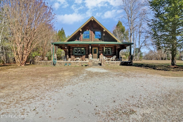 log home with metal roof, log exterior, and a porch