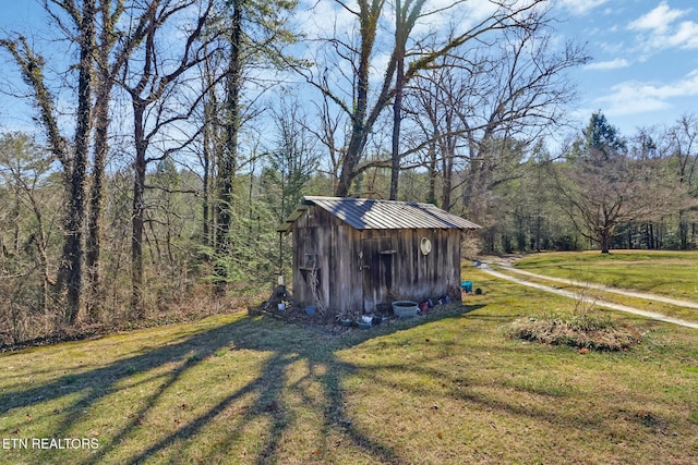 view of shed featuring a forest view and driveway