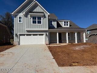 craftsman-style home with a garage, concrete driveway, board and batten siding, and covered porch