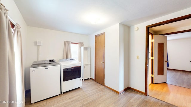 washroom with washer and clothes dryer and light hardwood / wood-style floors