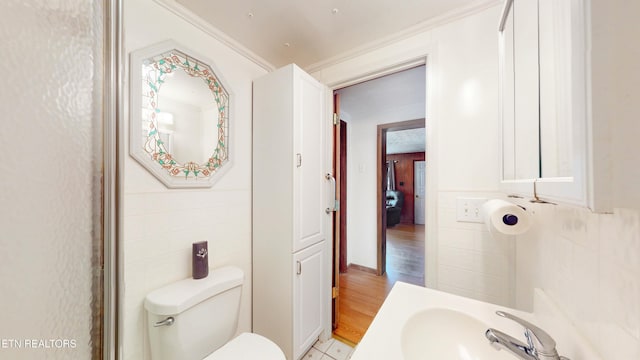 bathroom featuring sink, crown molding, and toilet