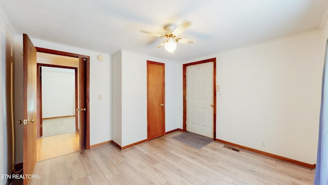 unfurnished bedroom featuring crown molding, a closet, ceiling fan, and light wood-type flooring