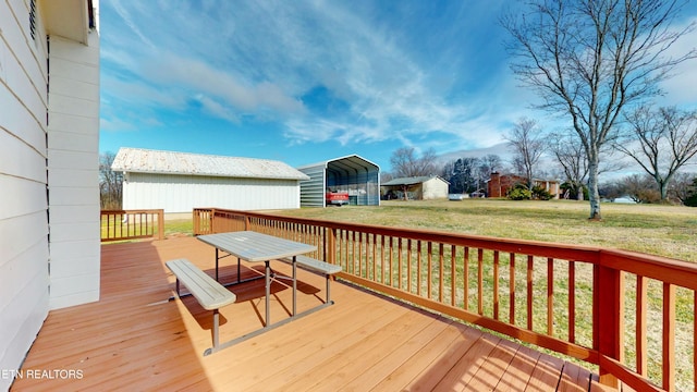 wooden terrace featuring a yard and a carport