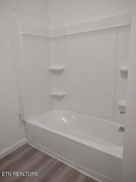 bathroom featuring bathtub / shower combination and hardwood / wood-style floors