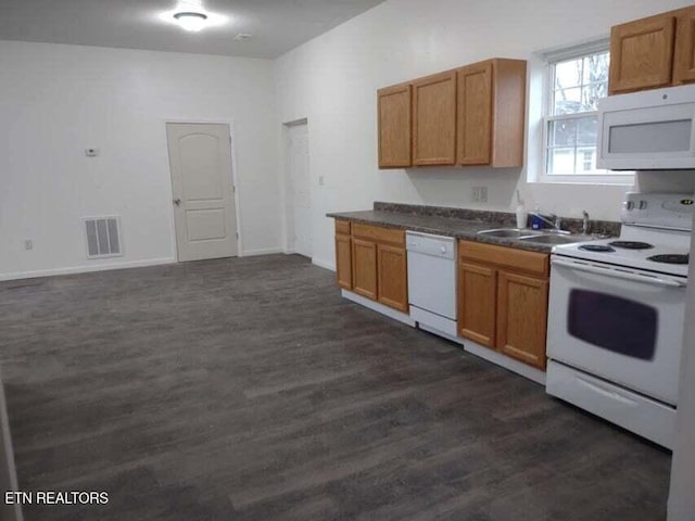 kitchen featuring white appliances, dark hardwood / wood-style flooring, and sink