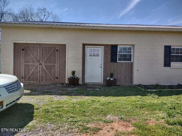 entrance to property featuring a lawn