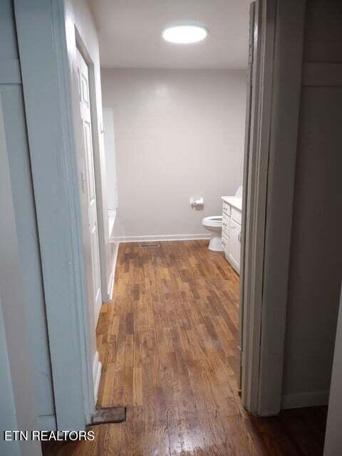 bathroom with wood-type flooring, vanity, and toilet