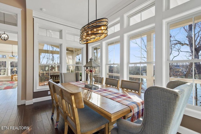 dining area featuring ornamental molding, dark wood-style flooring, a wealth of natural light, and baseboards