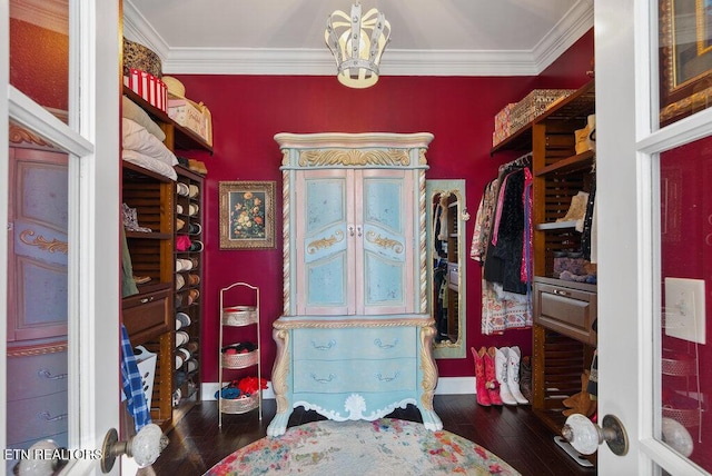 spacious closet featuring dark wood-style floors and an inviting chandelier