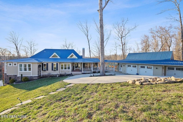 view of front of home featuring a porch, a front yard, metal roof, and a chimney