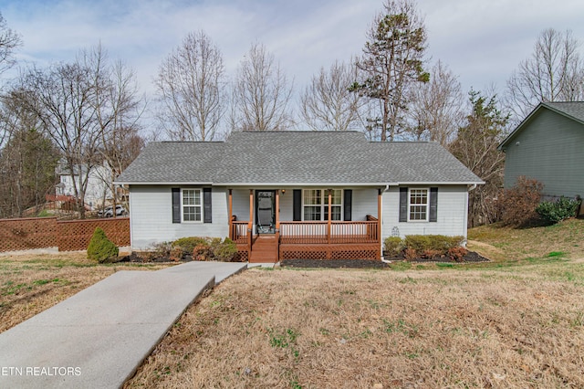 single story home featuring roof with shingles, covered porch, and a front yard