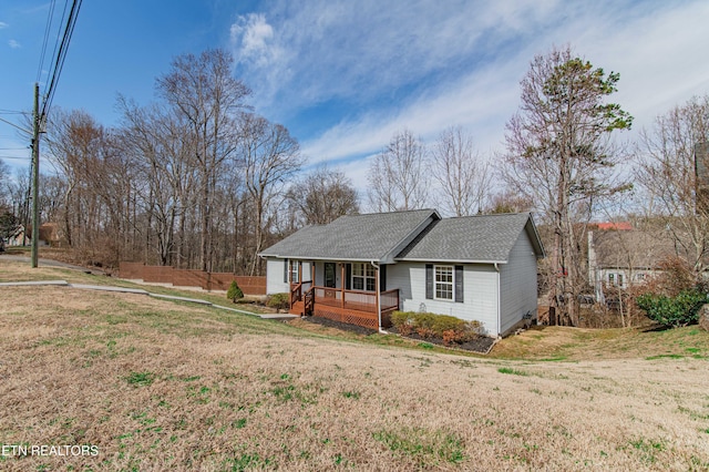 ranch-style house with covered porch, a front lawn, and a shingled roof