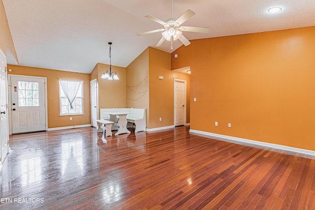 interior space featuring ceiling fan with notable chandelier, vaulted ceiling, and wood-type flooring