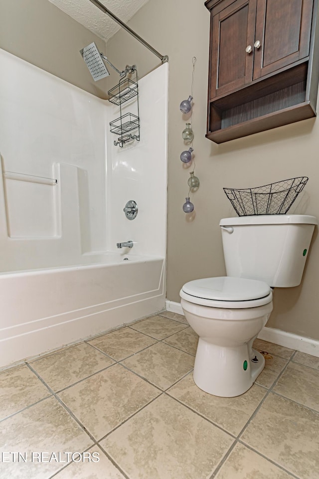 bathroom with washtub / shower combination, toilet, tile patterned flooring, and a textured ceiling