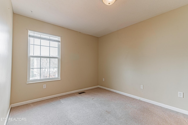 unfurnished room featuring a textured ceiling and carpet