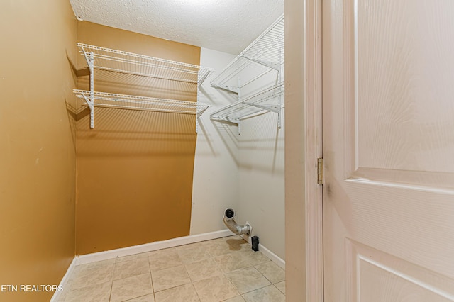 washroom featuring tile patterned flooring and a textured ceiling