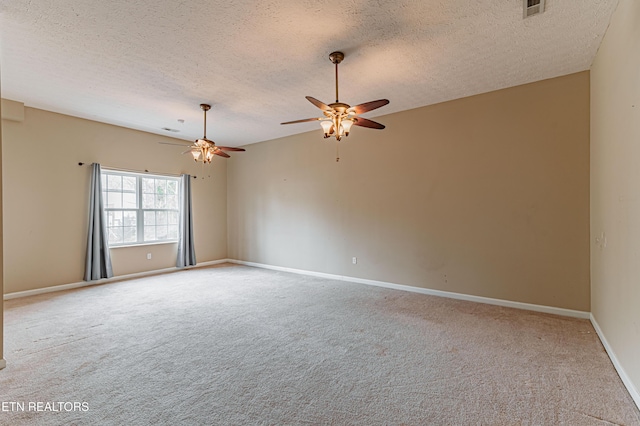 carpeted empty room with ceiling fan and a textured ceiling