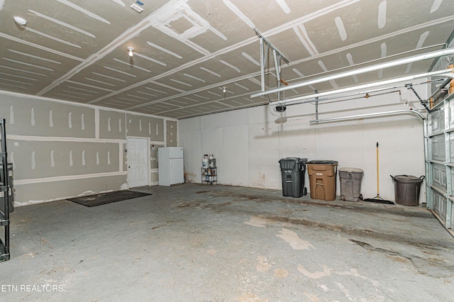 garage featuring a garage door opener and white fridge