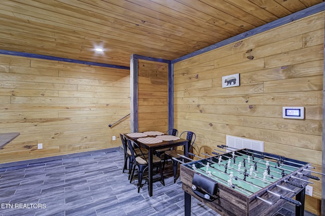 game room featuring wood ceiling and wood walls