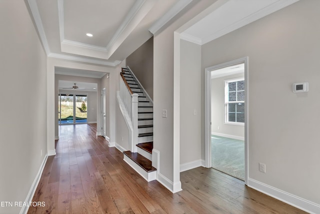 entryway with stairway, baseboards, ceiling fan, ornamental molding, and hardwood / wood-style flooring