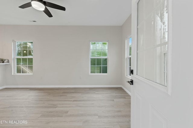 spare room with light wood-style floors, visible vents, baseboards, and a ceiling fan