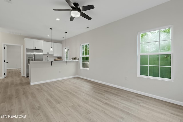 unfurnished living room with light wood-type flooring, baseboards, a ceiling fan, and recessed lighting