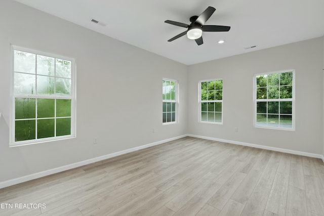 spare room featuring visible vents, light wood-style flooring, and baseboards