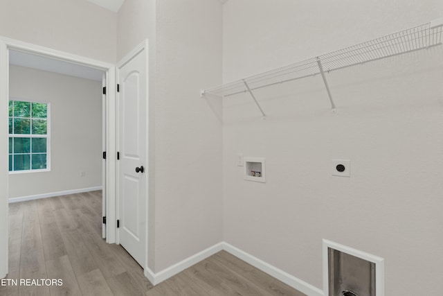 laundry area with hookup for a washing machine, light wood-style flooring, laundry area, baseboards, and electric dryer hookup