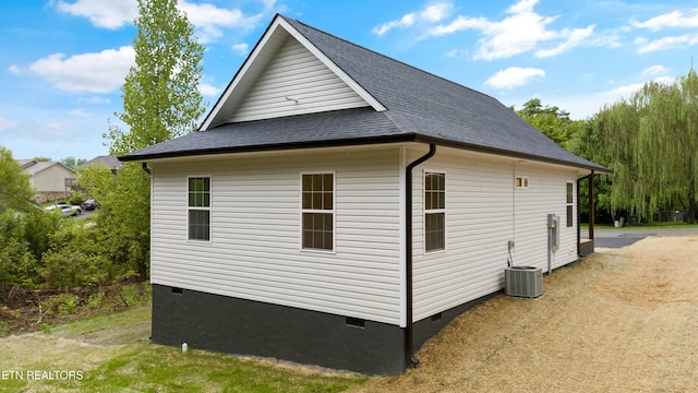 view of home's exterior featuring crawl space, cooling unit, and roof with shingles