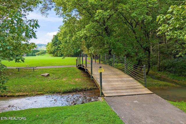 view of community with a water view and a lawn