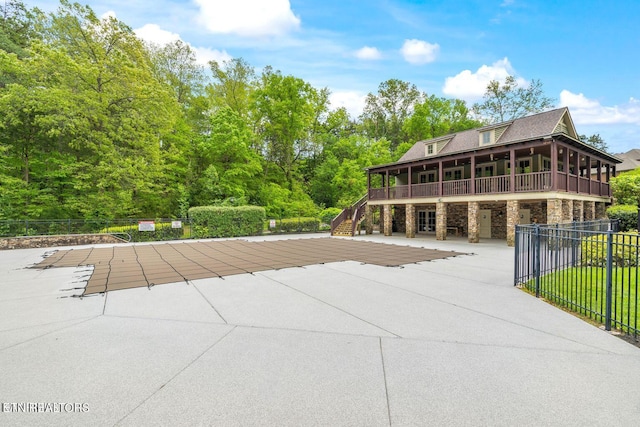 exterior space featuring stone siding, stairway, a patio area, and fence