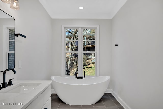 bathroom featuring baseboards, a freestanding bath, recessed lighting, tile patterned floors, and vanity