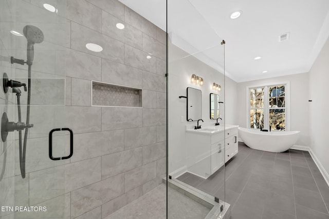 bathroom with vanity, baseboards, visible vents, a freestanding tub, and a stall shower